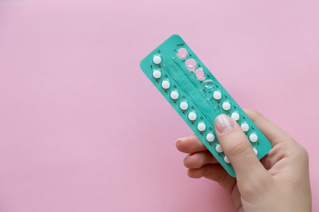girl holds in her hand oral contraceptives